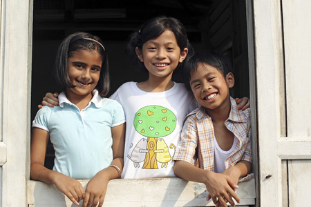 Children standing by the windowの写真素材