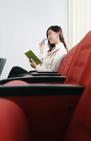 Woman contemplating while holding a notebookの写真素材