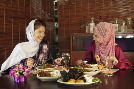 Women talking while eating togetherの写真素材