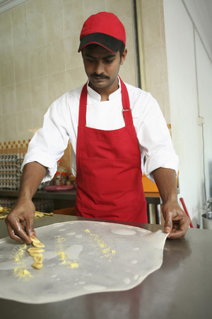 Man arranging banana slices onto flattened doughの写真素材