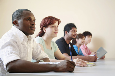 Men and women listening to a lecture in the classroomの写真素材