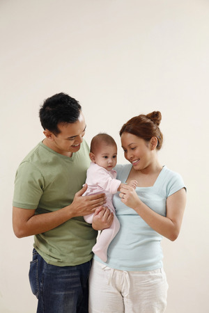 Woman carrying baby, man watchingの写真素材