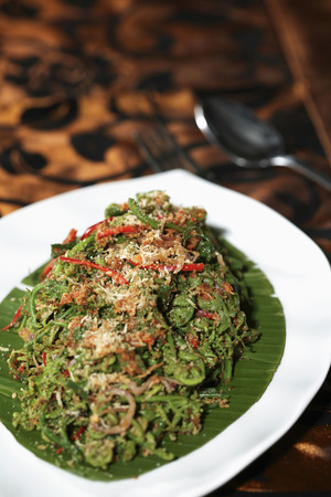 Wild fern stir-fried with chilli, caramelized coconut and shrimpの写真素材
