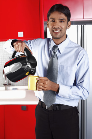 Businessman pouring coffee into his cupの写真素材