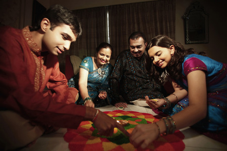Family drawing kolam on the floorの写真素材