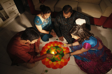 Family drawing kolam on the floorの写真素材