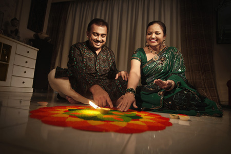 Man and woman drawing kolam on the floorの写真素材