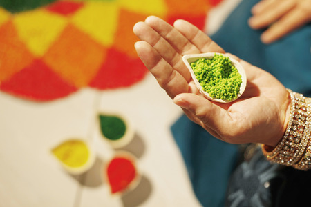 Woman's hand holding coloured rice powderの写真素材
