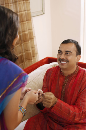 Man giving teenage girl a purple packetの写真素材