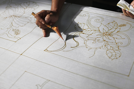 Man drawing batik patterns on fabricの写真素材