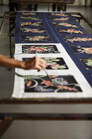 Man painting batik fabric