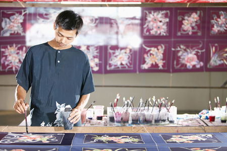 Man painting batik fabric