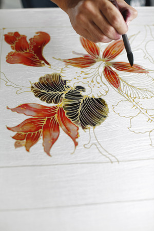 Man painting batik fabricの写真素材