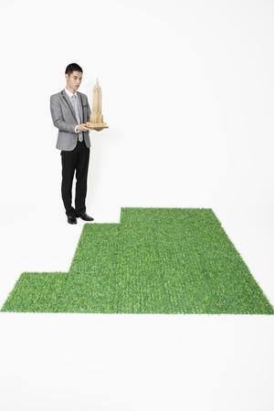 Businessman holding Empire State Building modelの写真素材
