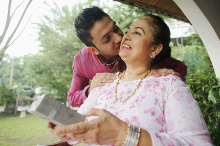 Man giving senior woman a peck on the cheekの写真素材