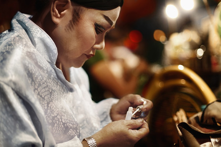 Opera performer applying glue on her fake lashesの写真素材