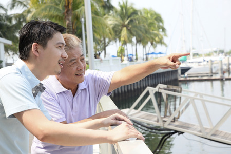 Father and son enjoying the lakeside view from the resortの写真素材
