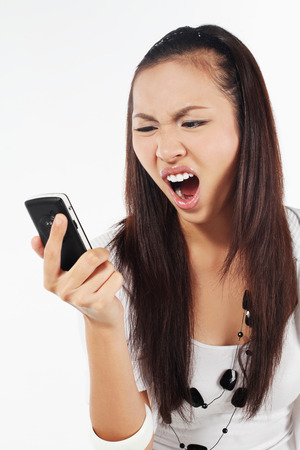 Woman screaming into mobile phoneの写真素材