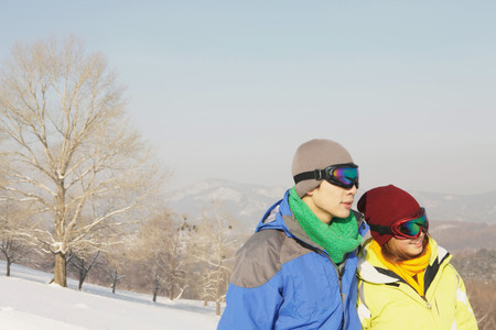 Man and woman with ski goggles looking awayの写真素材
