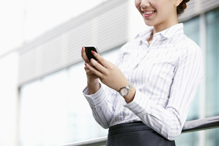 Businesswoman text messaging on smart phoneの写真素材