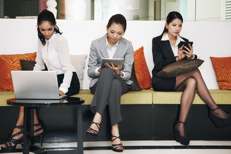 Businesswomen using electronic devicesの写真素材