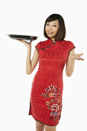 Woman in traditional clothing holding a tray in handの写真素材