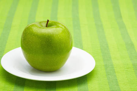 Green apple on a plateの写真素材
