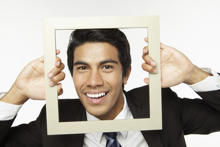 Young businessman holding empty picture frameの写真素材