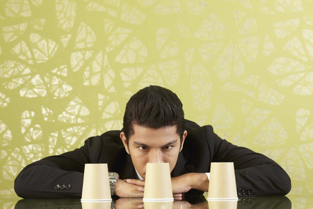 Young businessman playing the shell gameの写真素材