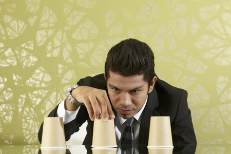 Young businessman playing the shell gameの写真素材