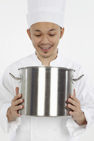 Surprised Asian chef looking into stew potの写真素材