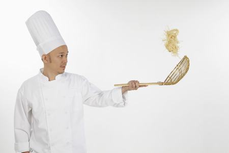 Asian chef tossing noodlesの写真素材