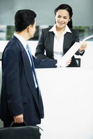 Sales representative interacting with a customer at the counterの写真素材