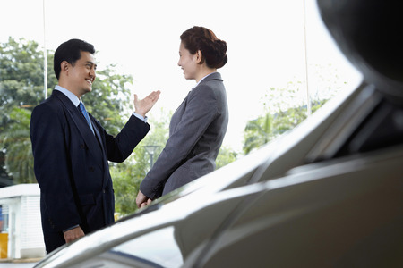 Business people having discussion in a car showroomの写真素材
