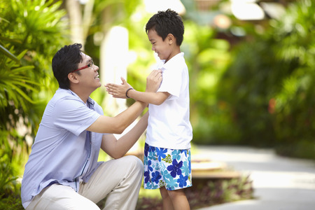 Man adjusting son's shirtの写真素材