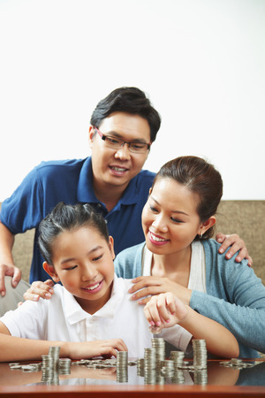 Family with stacks of coinsの写真素材