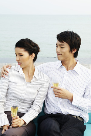 Businessman touching businesswoman, businesswoman looking uncomfortableの写真素材
