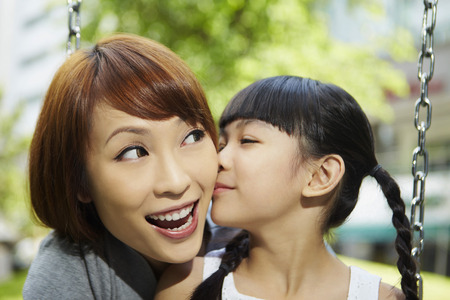 Daughter giving her mother a kissの写真素材