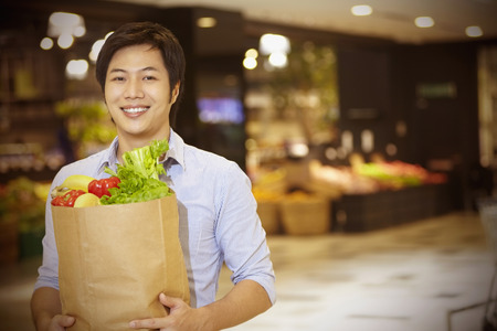 Man holding a bag of groceriesの写真素材