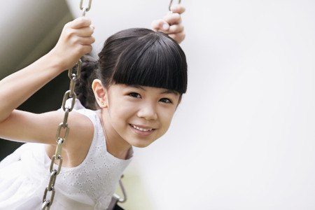 Girl sitting on the swingの写真素材