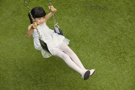 Girl sitting on a swingの写真素材