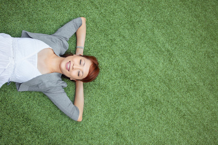 Woman lying down on the grassの写真素材