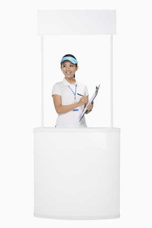 Woman standing behind a boothの写真素材