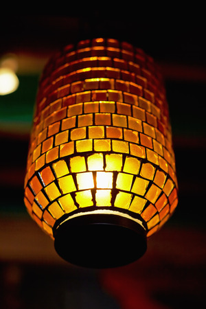 Lit mosaic lamp in the darkの写真素材