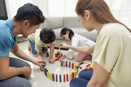 Family of four playing with building blocksの写真素材