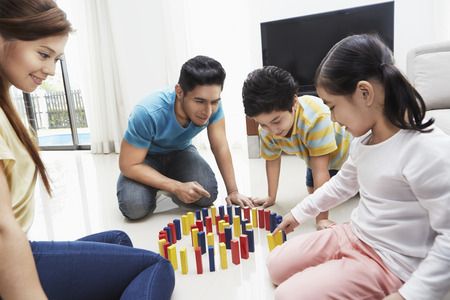 Family of four playing with building blocksの写真素材