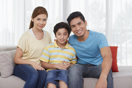 Family of three smiling at the cameraの写真素材