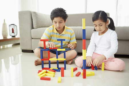 Boy and girl playing with colorful blocksの写真素材