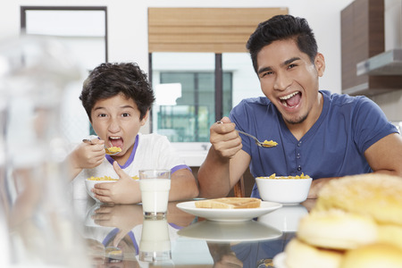 Father and son eating cerealsの写真素材