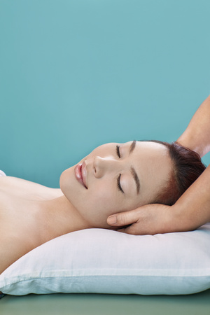 A young woman getting a head massageの写真素材